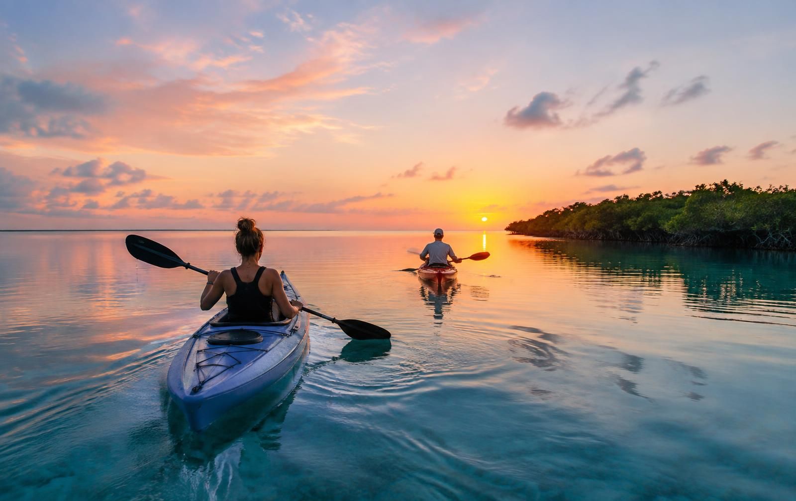 Two kayakers on the Bacalar lagoon at sunrise