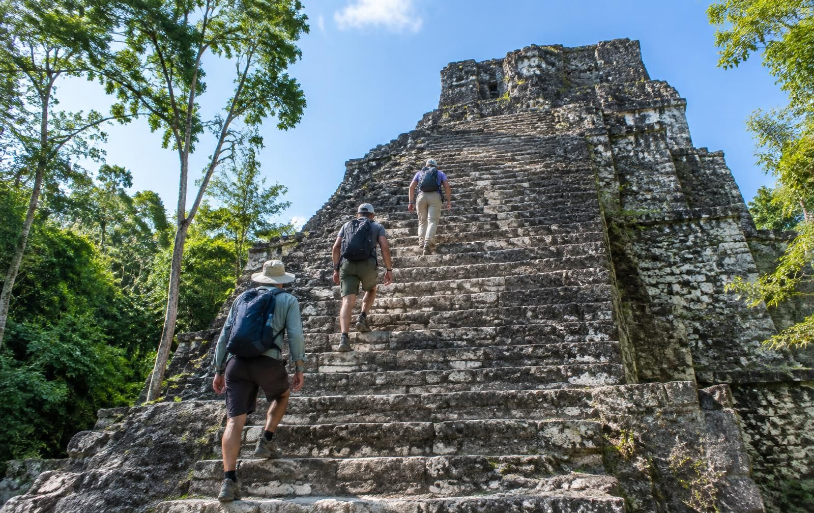 Viajeros subiendo un templo maya en Calakmul