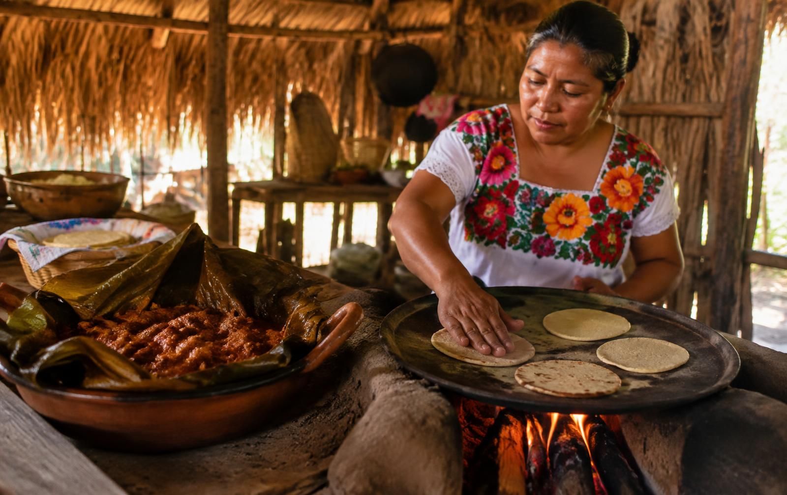 A Maya cook making tortillas in a village kitchen